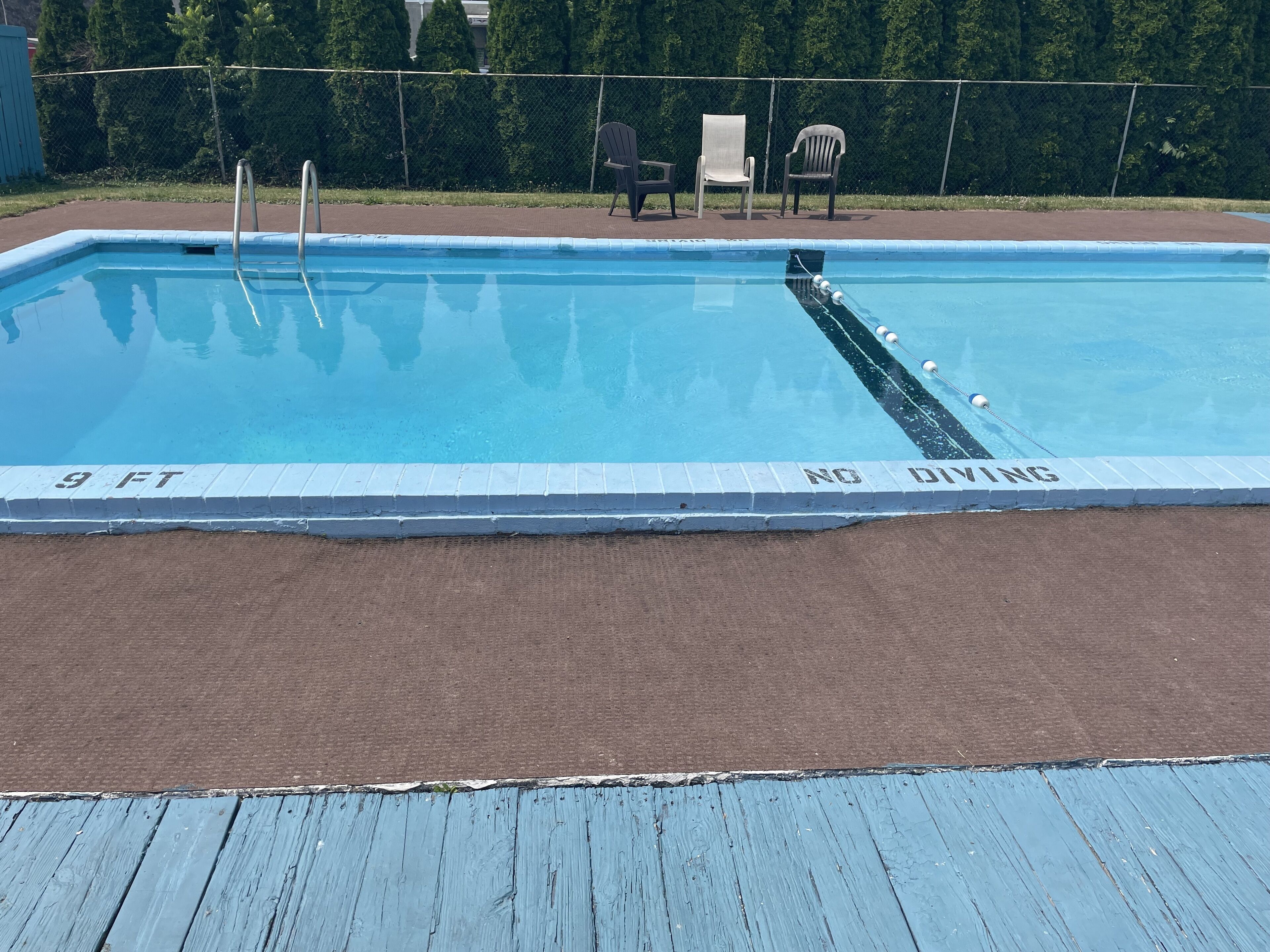 A swimming pool with a 9 FT depth marking and a 'NO DIVING' sign.