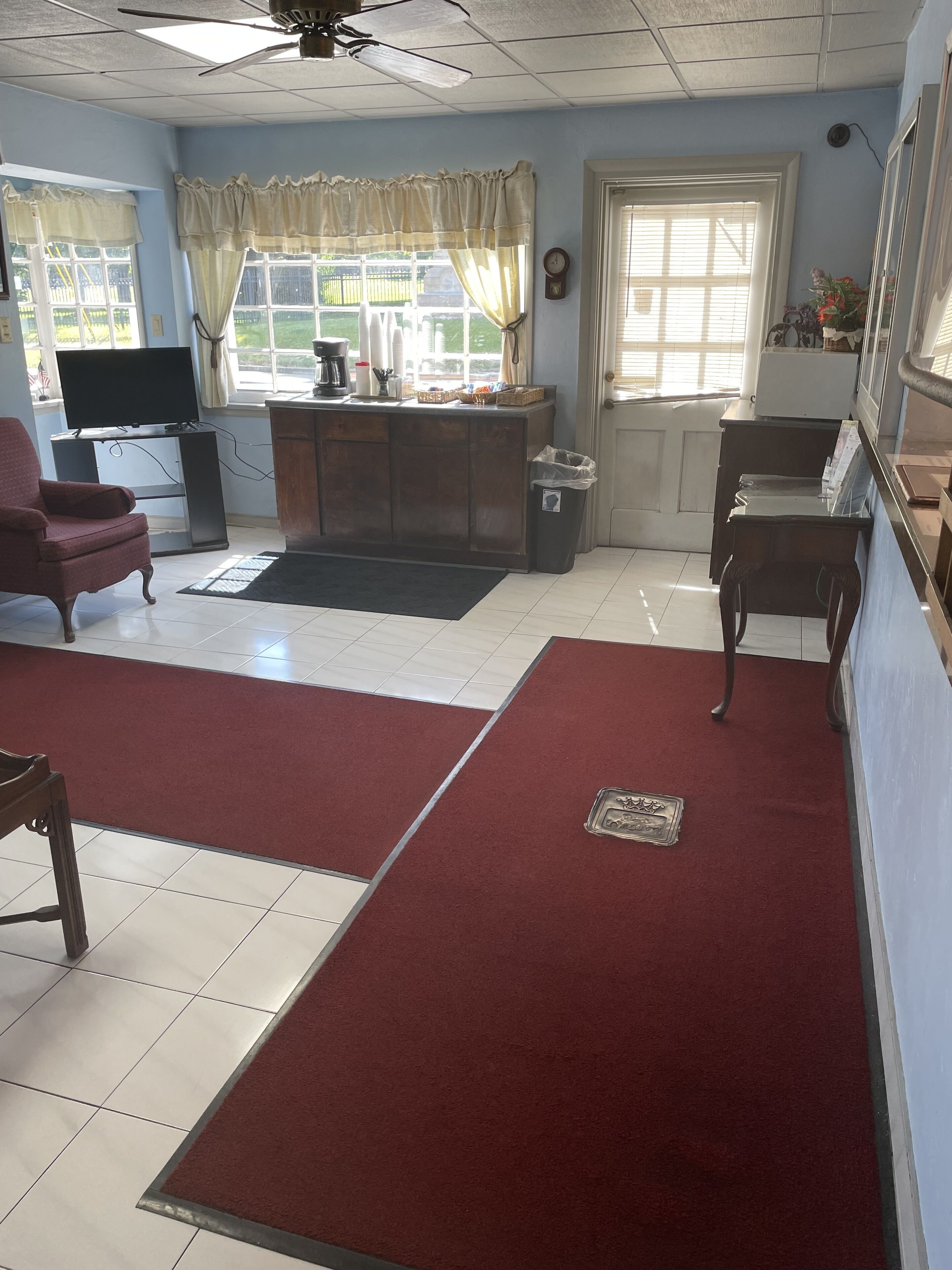 A living room with a TV, a coffee maker, and a trash bin.