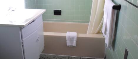 A bathroom with a toilet, sink, and bathtub.