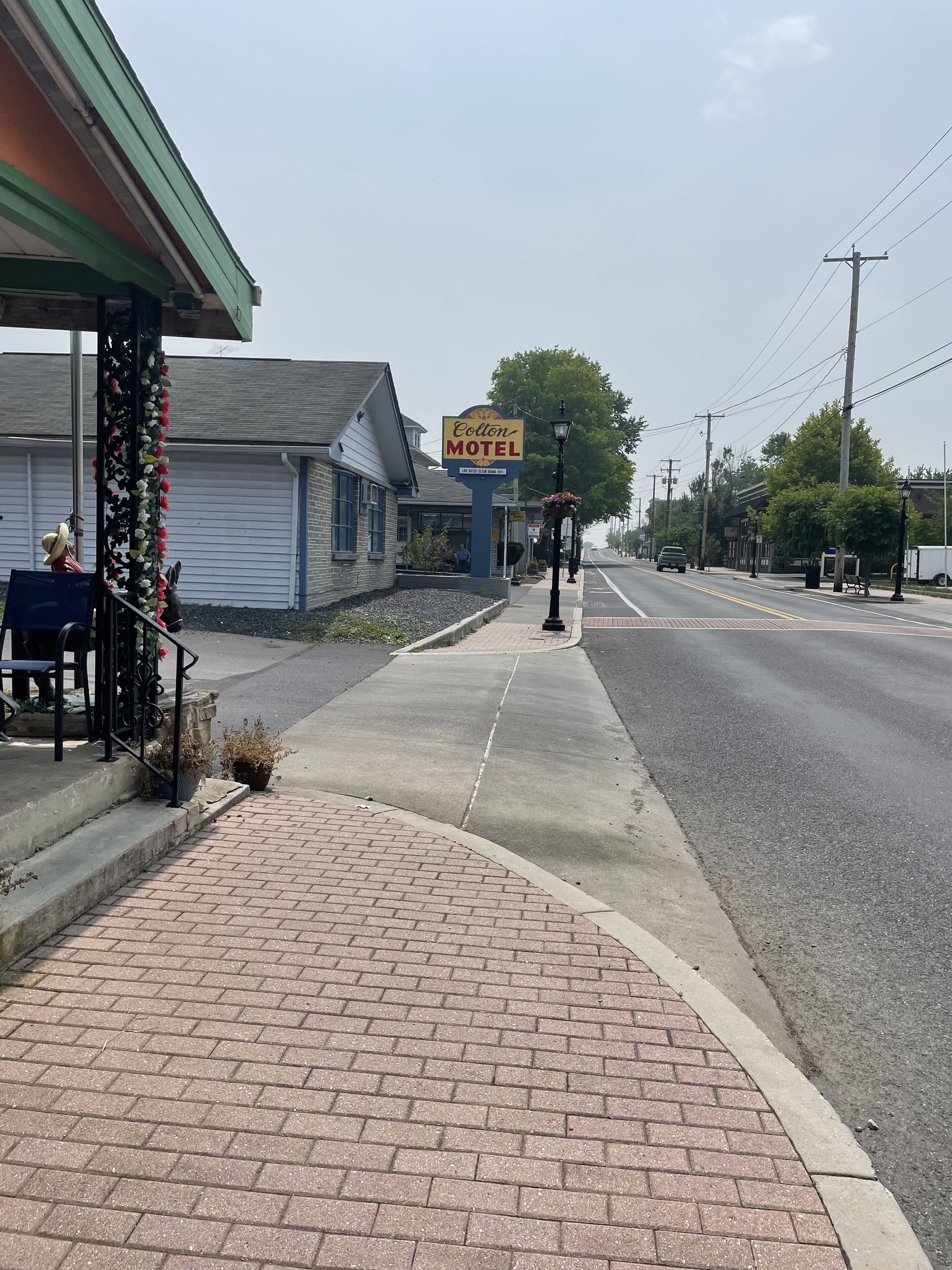 A motel with a signboard, a sidewalk, and a street.