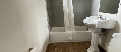 A bathroom with a bathtub, toilet, and sink.