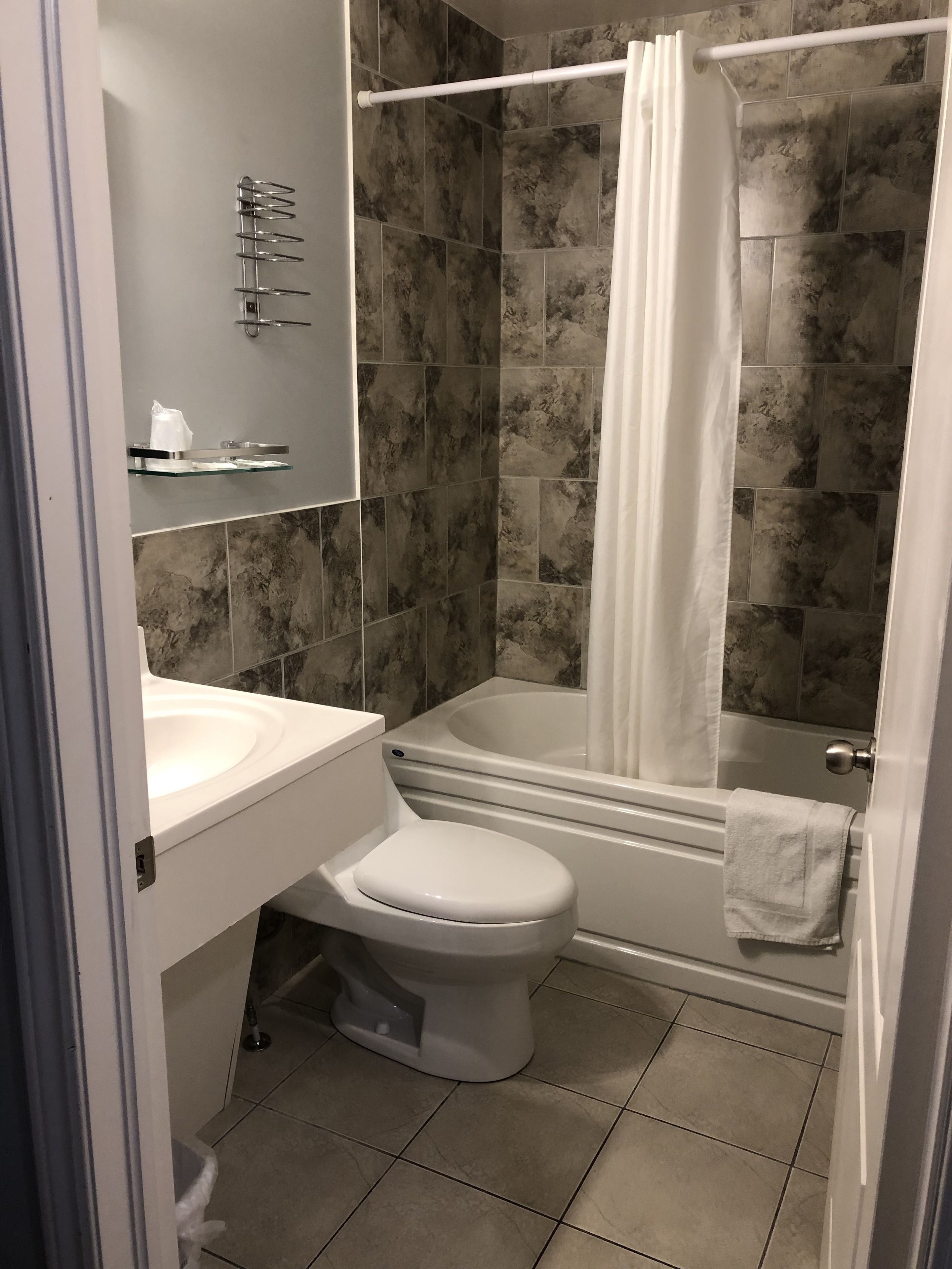 A modern bathroom with a toilet, sink, and bathtub.