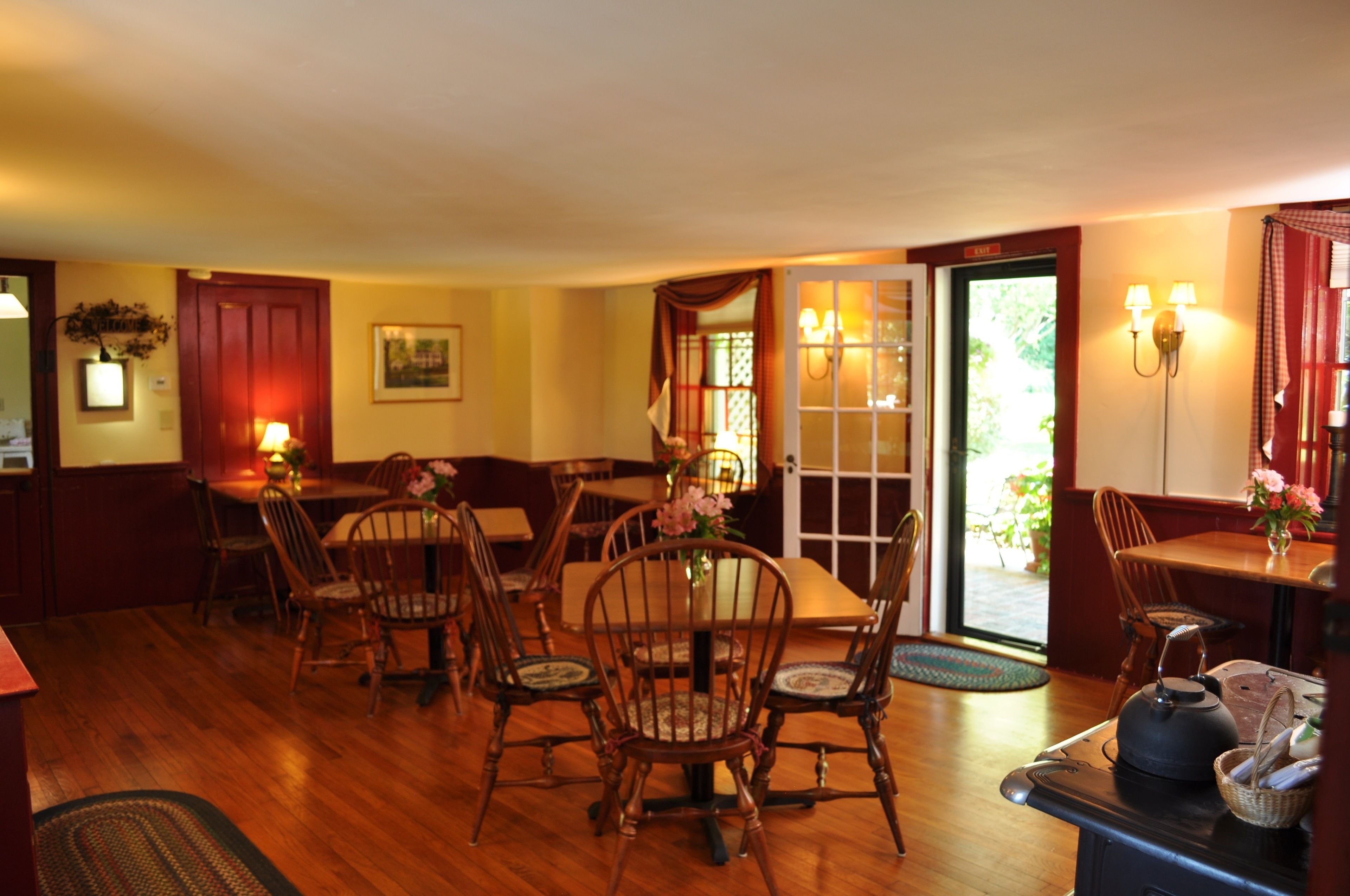 A dining area with wooden furniture, a stove, and a door leading outside.