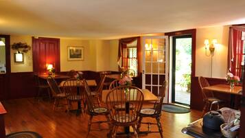 A dining area with wooden furniture, a stove, and a door leading outside.