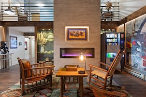 A lobby with a fireplace, wooden furniture, and a vending machine.