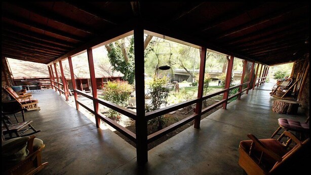 A spacious room with a large window, wooden furniture, and a concrete floor at RiverView Lodge in Kernville, CA. - Riverview Lodge (Kernville)
