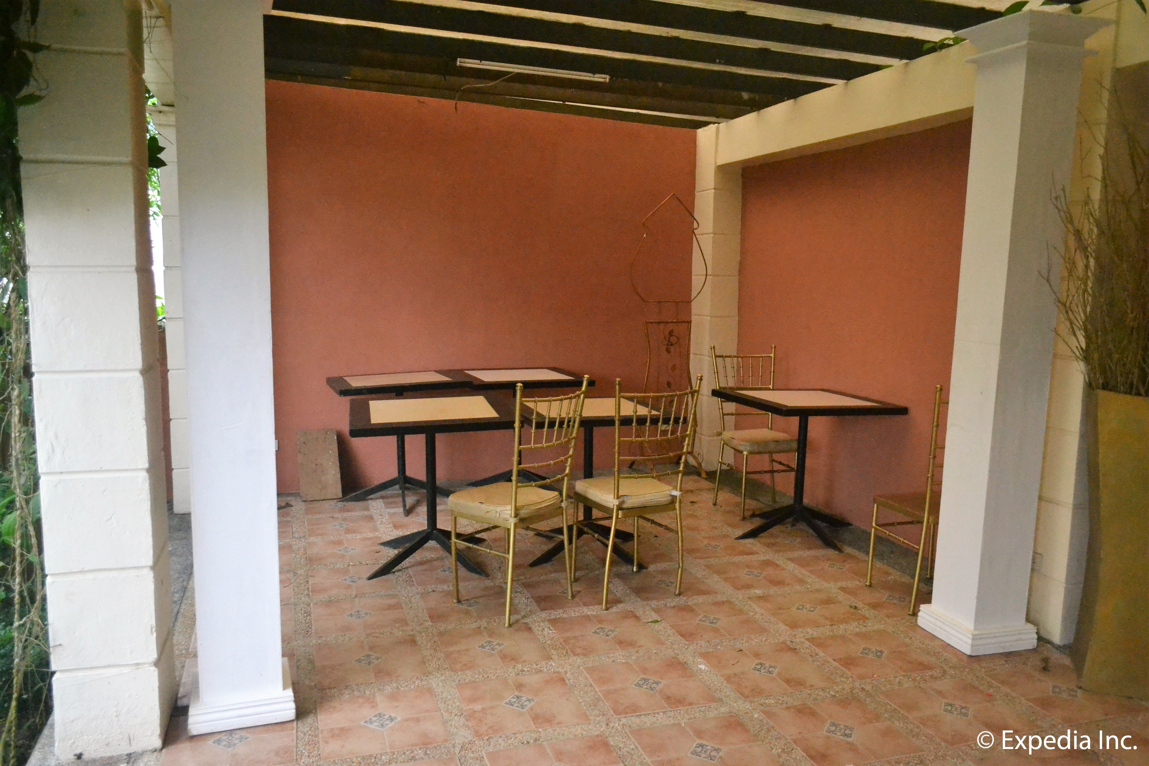 A room with a tiled floor, white columns, and a pink wall.