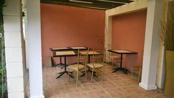 A room with a tiled floor, white columns, and a pink wall.
