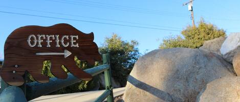 Un letrero de madera con la palabra 'OFFICE' y una flecha señalando a la derecha.