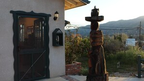 A building with a large glass door, a wooden sculpture, and a sign for Barewood Inn & Suites.