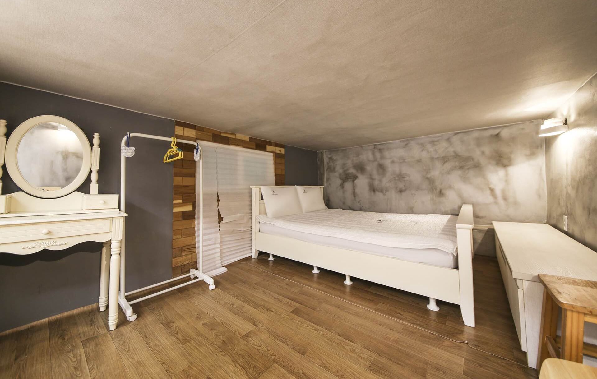 A bedroom with a bed, a dresser, a mirror, and a radiator.