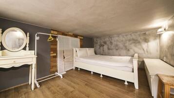 A bedroom with a bed, a dresser, a mirror, and a radiator.