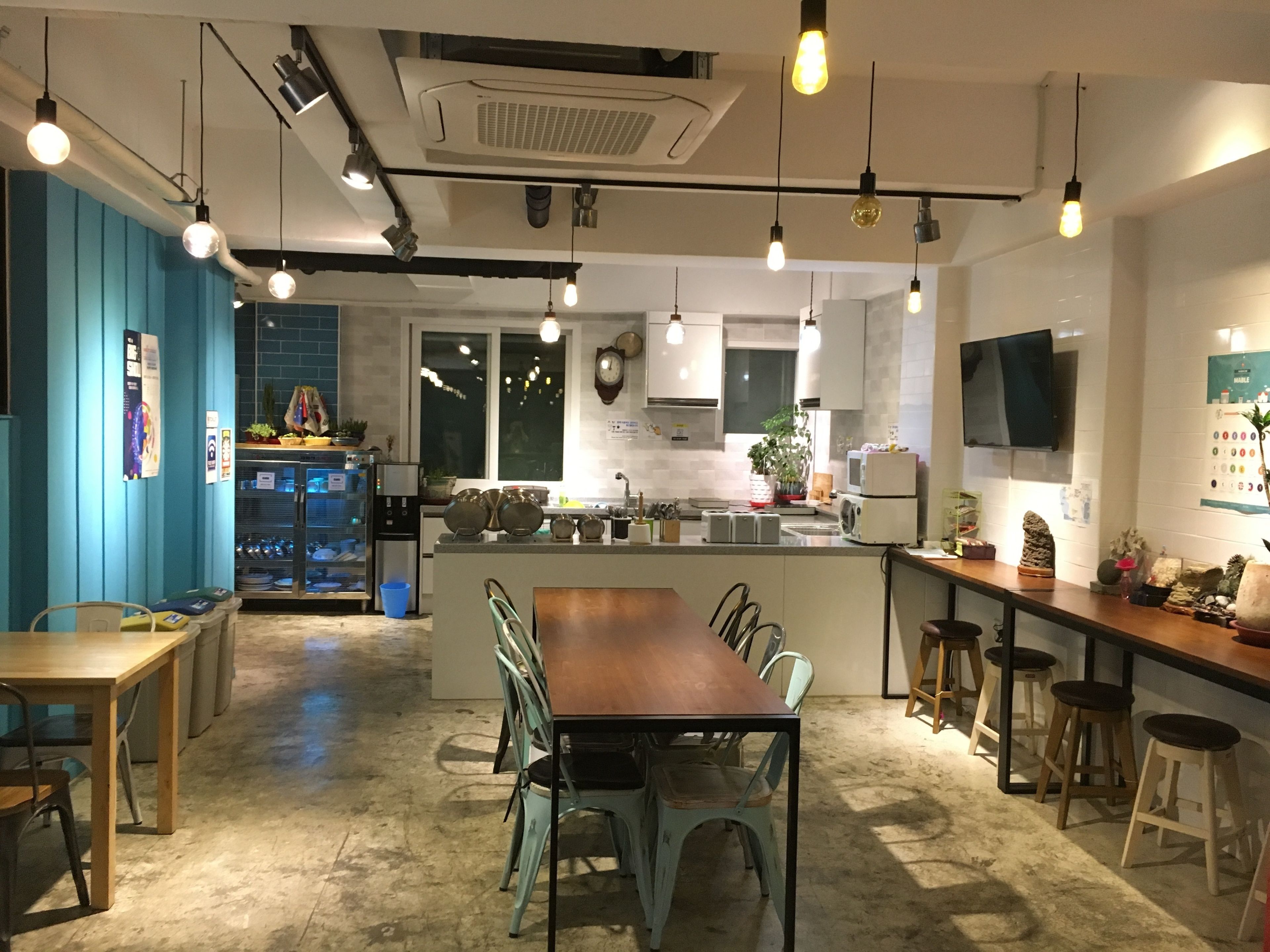 Una cocina moderna con una isla central, taburetes de bar y una zona de comedor con sillas.