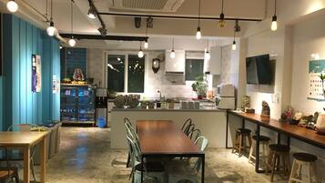 Una cocina moderna con una isla central, taburetes de bar y una zona de comedor con sillas.
