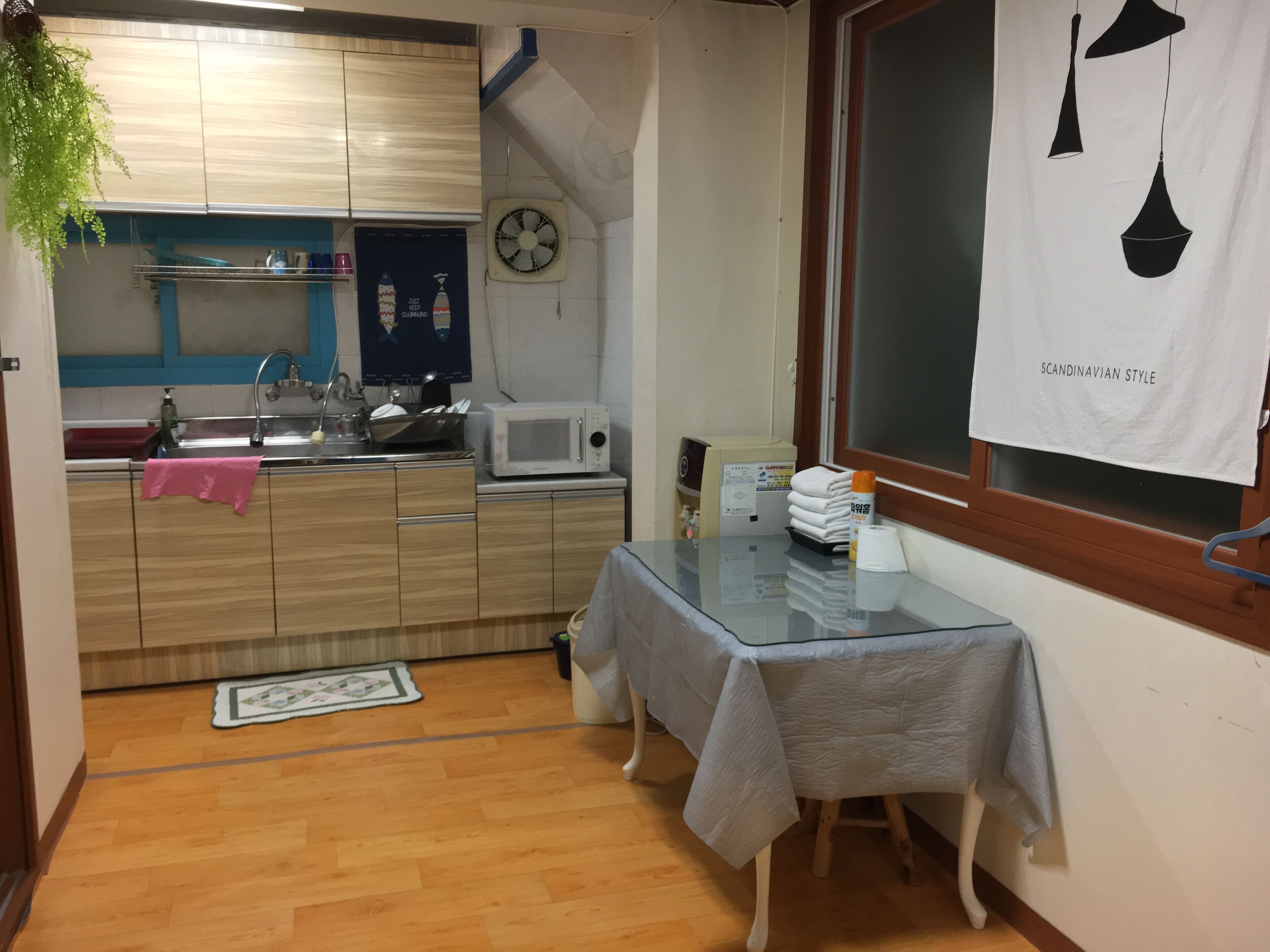 A compact kitchen with a microwave, sink, and a small dining table.