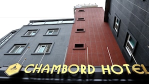 La façade extérieure de l’hôtel Chambord, avec une enseigne indiquant son nom.