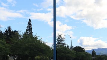 A motel sign with a blue pole and a tire at the base.