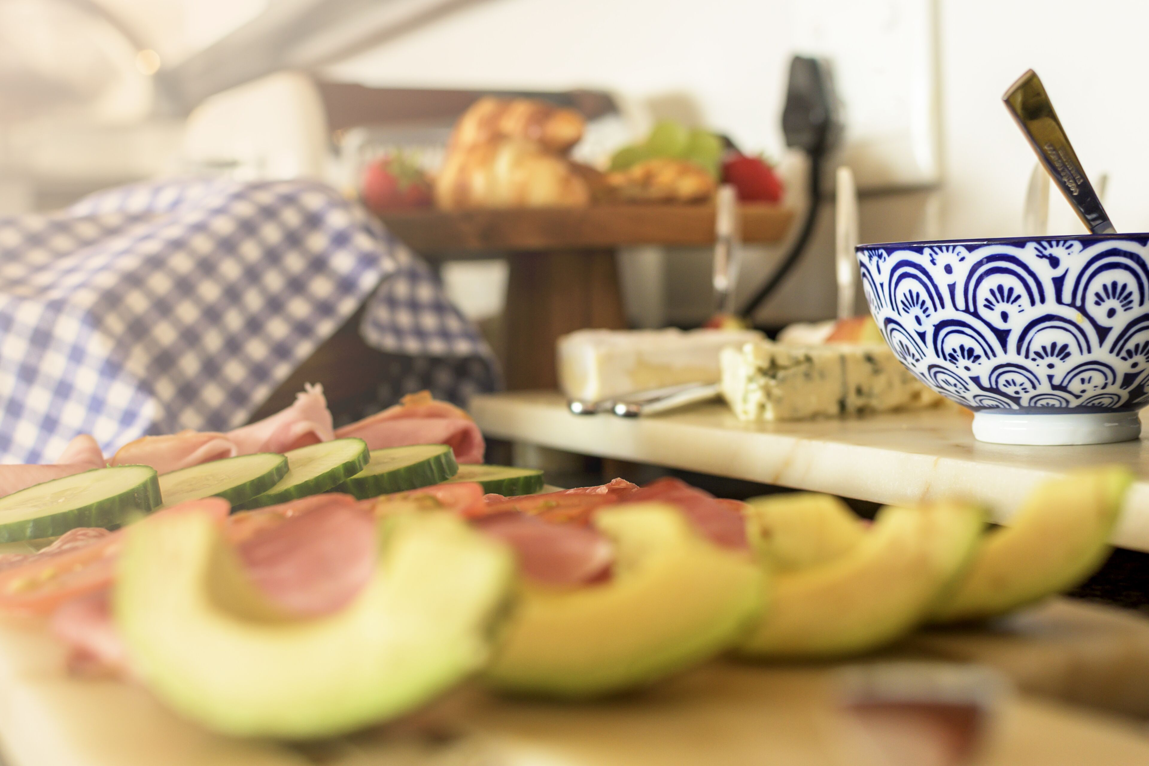 A table with sliced fruits and a bowl of yogurt.