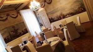 A formal dining room with white tablecloths, chairs, and a chandelier. - Antica Dimora B&B in Historic Residence (Bergamo)