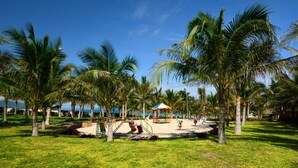 A park with palm trees, a playground, and a beach area. - Dessole Beach Resort Nha Trang (Cam Lam)