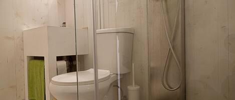 A bathroom with a toilet, a shower, and a sink.