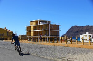 Un edificio de varios pisos con balcones y un letrero que dice 'AQUILES eco-hotel'.