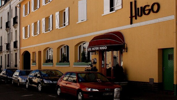 A yellow building with the sign "Hotel Victor Hugo" and a red awning. - Hotel Victor Hugo (Dijon)
