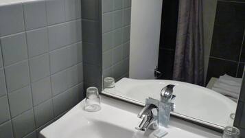 A bathroom with a white sink, a mirror, and a shower curtain.