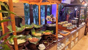 A buffet with various dishes served on banana leaves, a large pot, and multiple bowls and plates. - Lorin Syariah Solo Hotel (Colomadu)