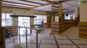 Step into a stylish lobby with a central staircase, geometric-patterned floor, and comfortable seating areas.