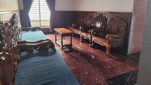 A room with a long wooden bench, a sofa, and a small table. - Jasmine Lodge (Siem Reap)