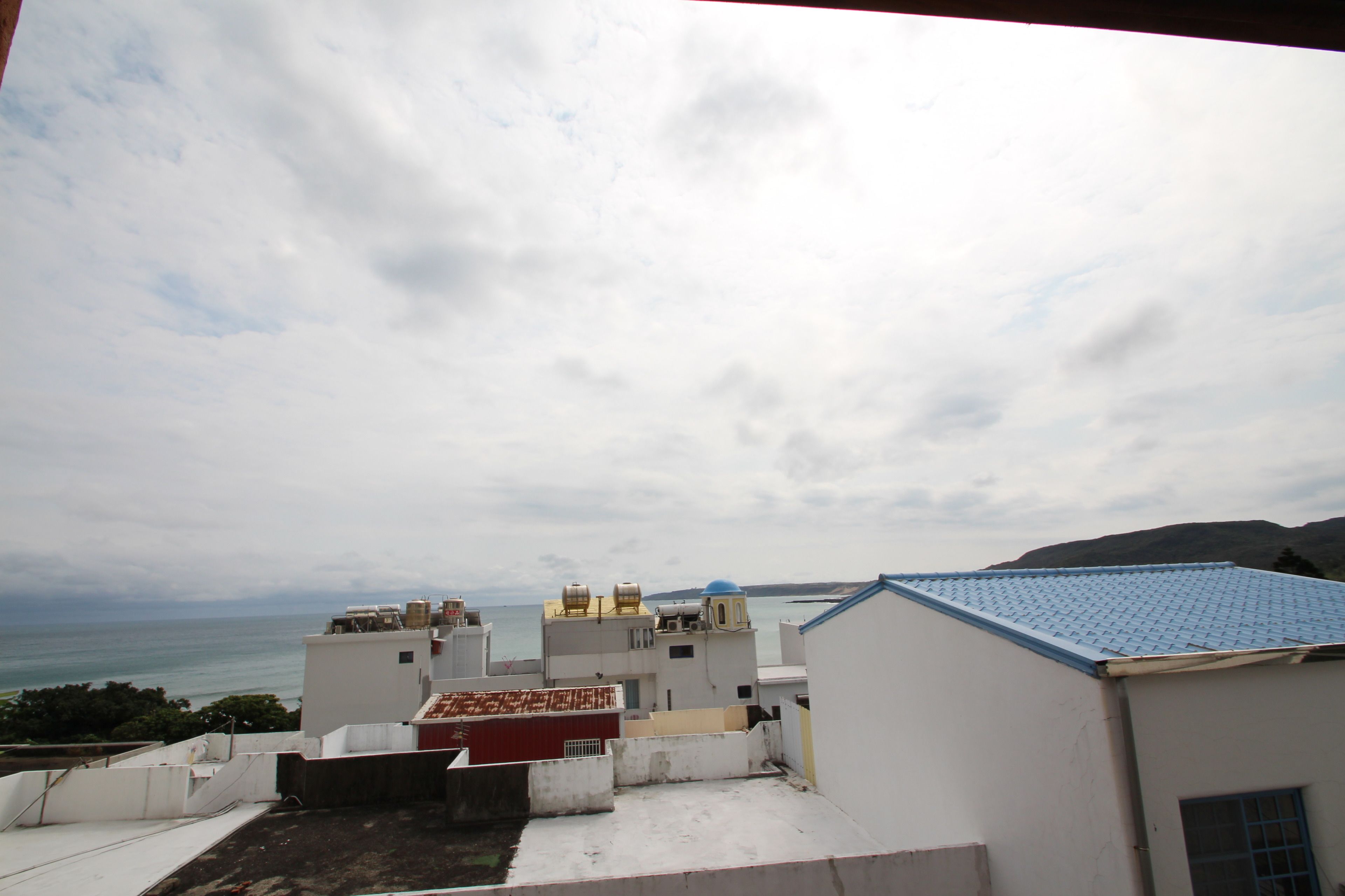 A view of a coastal area with buildings and a sea in the background.