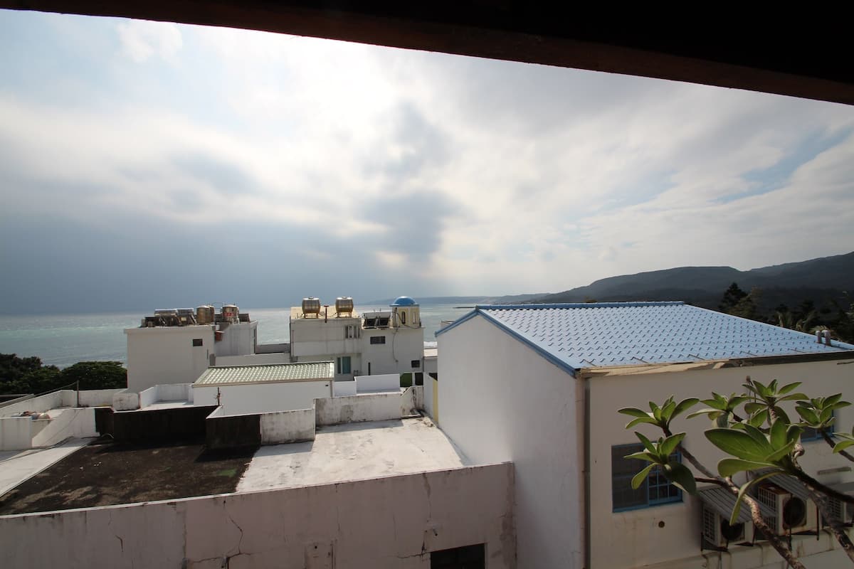 Eine Dachterrasse mit Blick auf das Meer und ferne Berge.