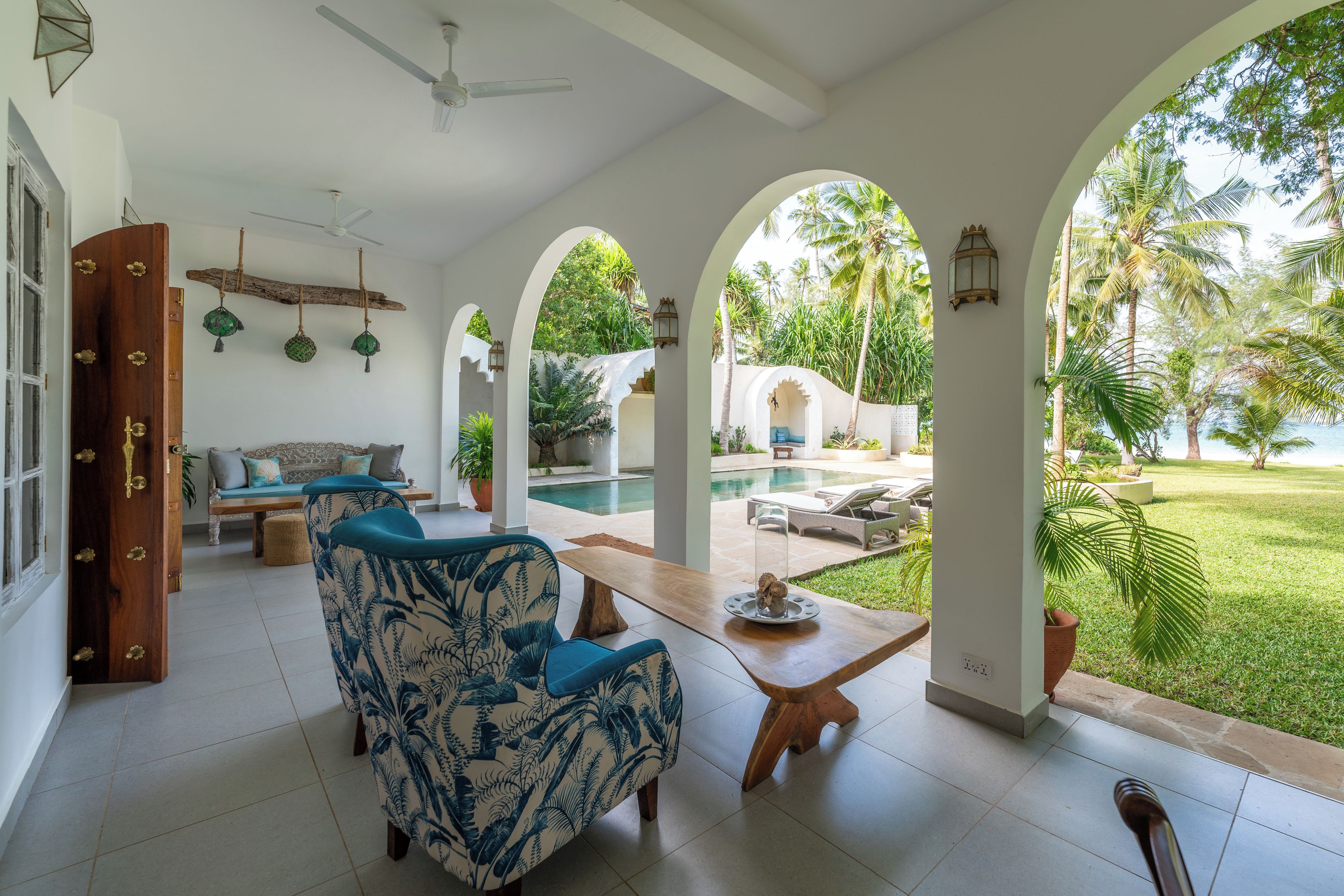 A spacious indoor area with a pool, seating, and natural light.