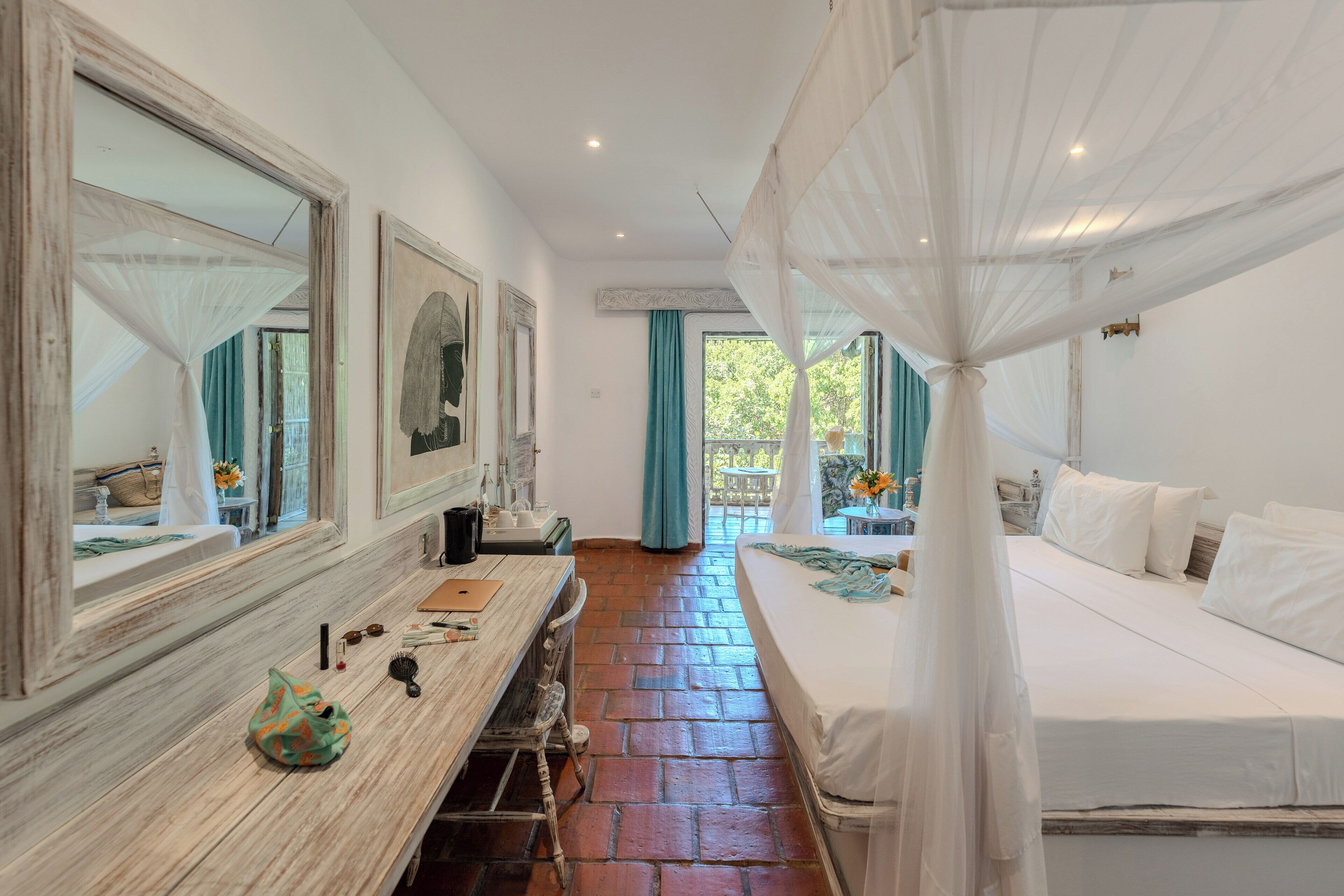 Un dormitorio con una cama, tocador, espejo y ventana con cortinas.