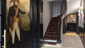 Una gran escalera con acabado de madera oscura y barandilla decorativa.