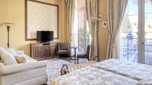 A hotel room with a bed, two armchairs, a TV, and a view of the outdoor patio. -  PortAventura Hotel Lucy's Mansion -Includes unlimited access & Express wristband to PortAventura Park & Ferrari Land (Vila-Seca)
