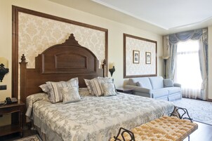 Un dormitorio con una cama grande, un sofá y una silla.