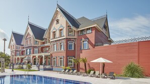 A large, multi-story building with a swimming pool in front. -  PortAventura Hotel Lucy's Mansion -Includes unlimited access & Express wristband to PortAventura Park & Ferrari Land (Vila-Seca)