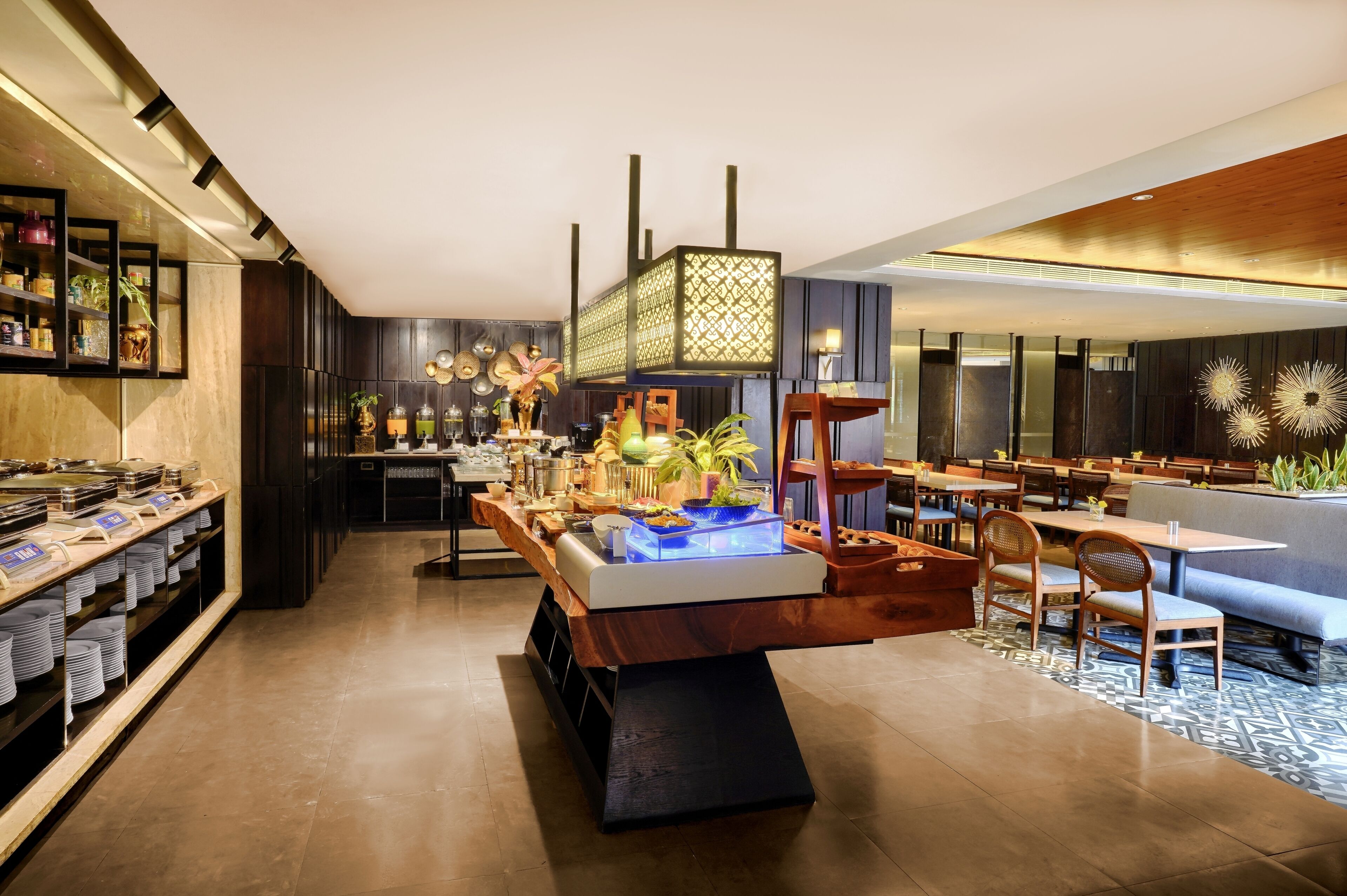 A modern restaurant with a long counter, wooden tables, and chairs.
