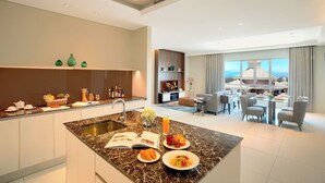 Cocina moderna con isla de mármol, comedor con vistas y sala de estar con chimenea.