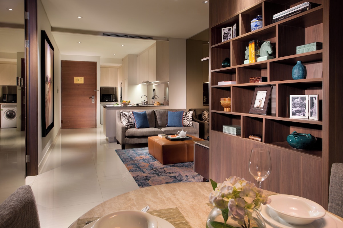 A modern living room with a sofa, coffee table, and a bookshelf.