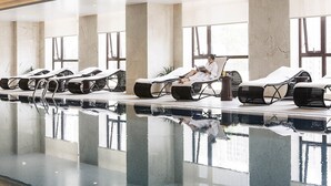 A spa area with reclining chairs, a pool, and large windows. - Pullman Taiyuan (Taiyuan)