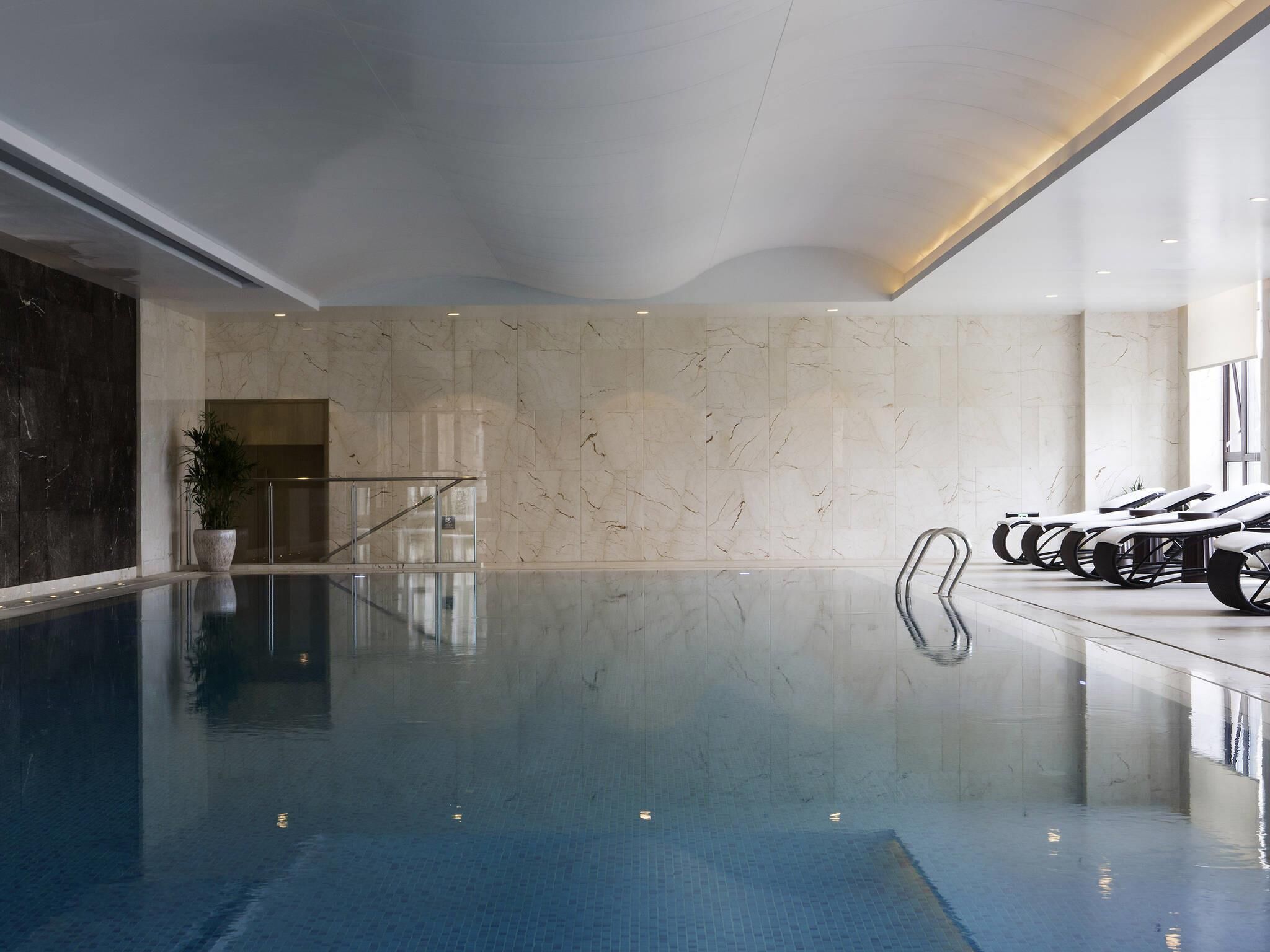 Una piscina cubierta, tumbonas