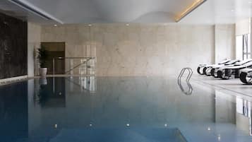 Una piscina cubierta, tumbonas