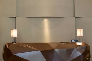 A reception desk with a geometric design and two lamps on either side. - Pullman Taiyuan (Taiyuan)