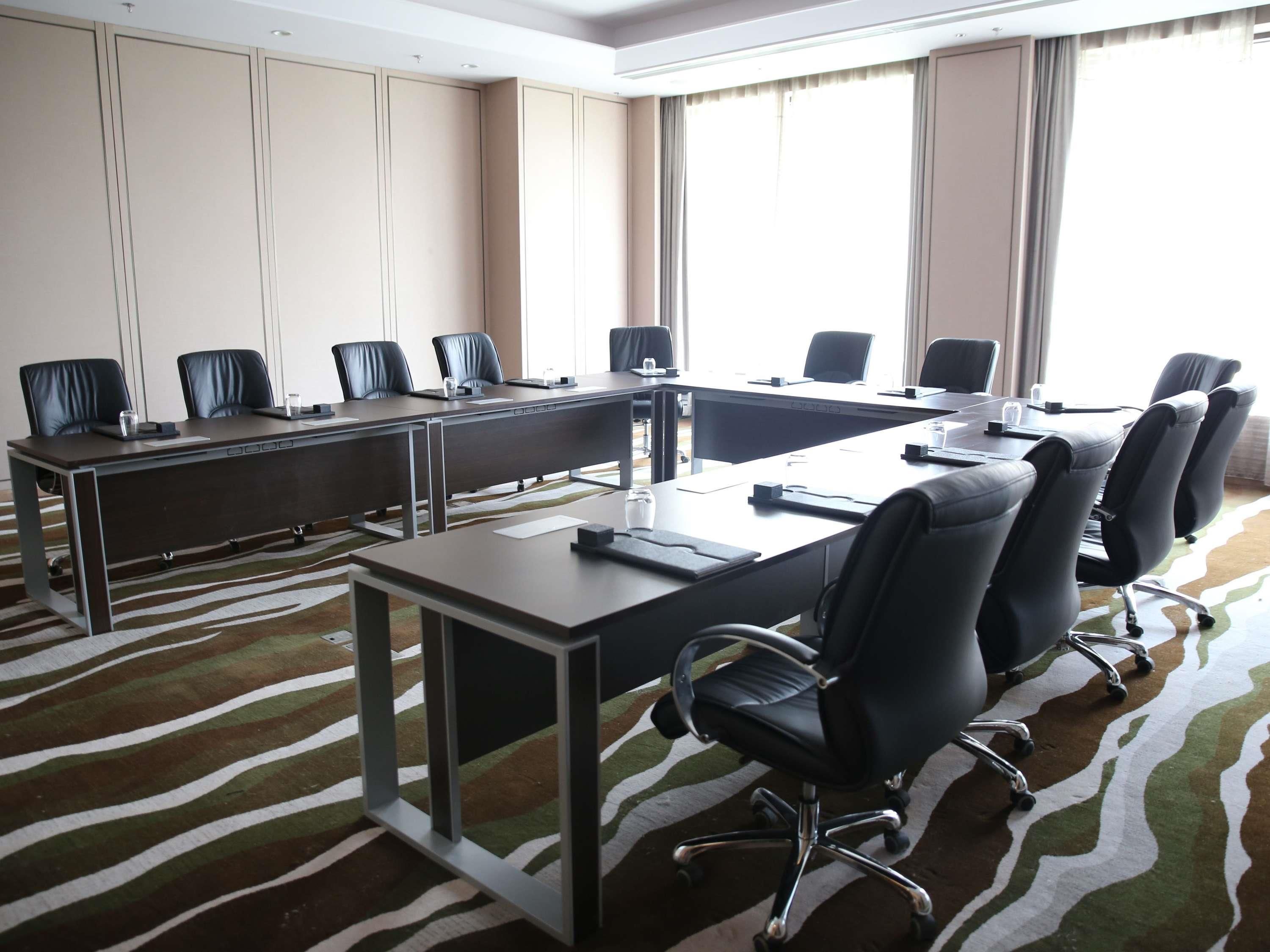 A conference room with a long table, multiple chairs, and a zebra-patterned carpet.