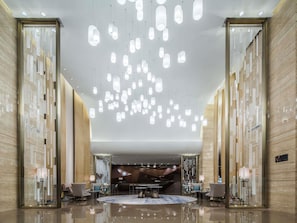 A spacious lobby with hanging pendant lights, a reception desk, and a modern interior design. - Pullman Taiyuan (Taiyuan)