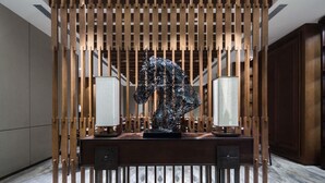 A modern interior with a desk, two lamps, and a decorative sculpture. - Pullman Taiyuan (Taiyuan)