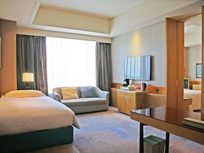 A hotel room with a bed, a sofa, a desk, and a television. - Pullman Taiyuan (Taiyuan)